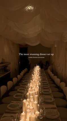 a long table with many lit candles on it and the words, the most stunning dinner set up