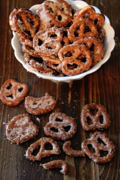 a bowl full of pretzels sitting on top of a wooden table