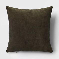 a dark green pillow on a white wall