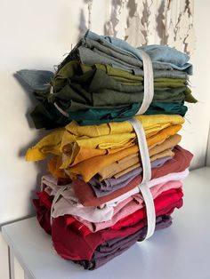 a stack of folded clothes sitting on top of a white table