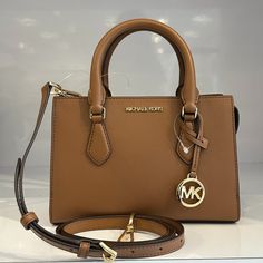 New With Tag Michael Kors Sheila Satchel Shoulder Crossbody Bag Vegan Leather Luggage 100% Authentic Retail: $498.00 Plus Tax **Please See The Measurement For The Size** No Dust Bag Michael Kors Logo At Front Gold Toned Hardware 1 Mk Charm Zip Top Closure Triple Compartment With Center Zip Custom Fabric Lining 1 Slip-In Pocket 9" (Bottom) X 6.5"(H) X 3"(D) Straps: 3.5" Adjustable Strap: 20.25"-23.75" Very Clean, Smoke-Free And Pet-Free Environment Brown Michael Kors Bag, Michael Kors Bag Brown, Sac Michael Kors, Dream Bags, Tan Shoulder Bag, Bag Michael Kors, Kate Spade Crossbody Purse, Michael Kors Logo, Mk Purse