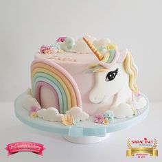 the cake is decorated with an unicorn's head and rainbows