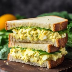 two sandwiches stacked on top of each other with lettuce and eggs in the middle