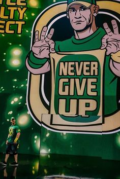 a man standing in front of a giant sign with the words never give up on it