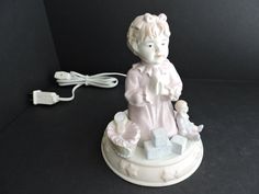 a white figurine sitting on top of a table next to a power cord