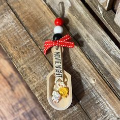 a wooden spoon with a red bow on it sitting on top of a wooden table