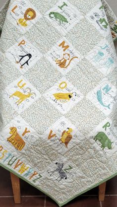 a baby quilt with animals and letters on it