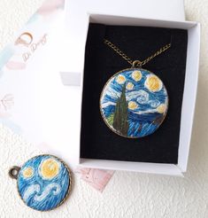 the starry night necklace is in its box next to it's keychain