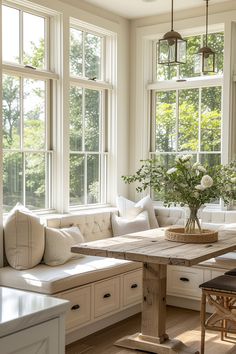 a living room filled with lots of windows next to a wooden table and couches