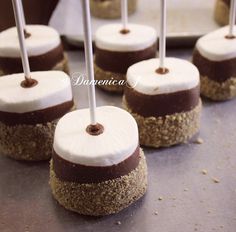 chocolate covered marshmallows with white frosting and brown sprinkles