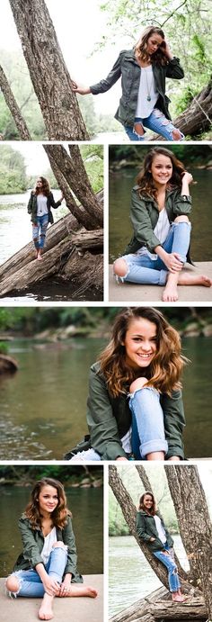 a woman sitting on top of a tree in front of a river and posing for the camera