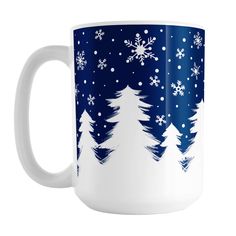 a blue and white coffee mug with snowflakes on the trees in the background