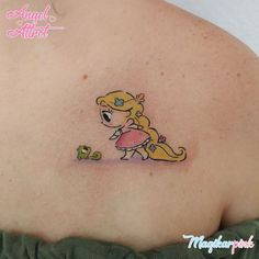 the back of a woman's shoulder with a cartoon character tattoo on her chest