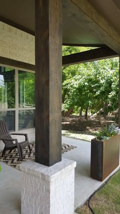 an outdoor patio with two chairs and a planter on the concrete floor next to it