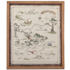 a cross stitch map in a wooden frame on a white background with wood trimmings