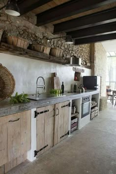 a kitchen with wooden cabinets and stone walls