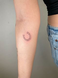 a woman's leg with a tattoo on it and a horseshoe in the middle