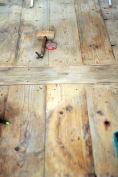 the floor is made out of wood and has tools on it, including a hammer