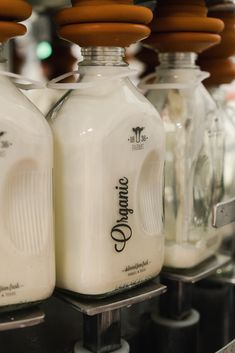 several glass milk bottles lined up on a shelf