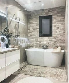 a white bath tub sitting inside of a bathroom next to a walk in shower stall