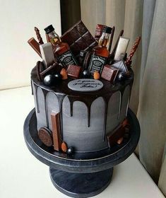 there is a cake with chocolates and liquor on the top, surrounded by other items