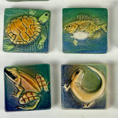 four ceramic coasters with different designs on them, including one turtle and the other fish