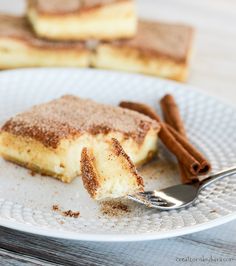 a piece of cake on a plate with cinnamon sticks