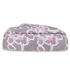 a purple and white flowered comforter on a white background