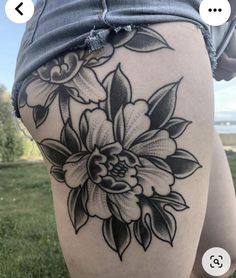 a woman's thigh with black and white flowers on it