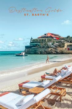 people are walking on the beach near lounge chairs