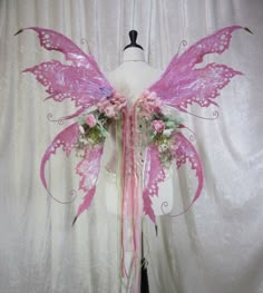 a white mannequin with pink wings and flowers