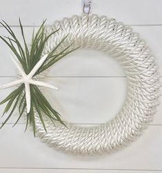 a white rope wreath hanging on the wall