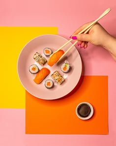 a plate with sushi and chopsticks on it