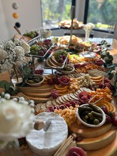 a table with many different types of food on it and flowers in vases next to each other