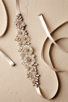 the bridal sash is adorned with flowers and pearls