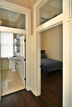 an open door leading to a bedroom with a bed and sink