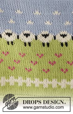 a knitted sweater with sheeps and flowers in blue, green, pink and white