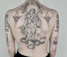 the back of a woman's upper body with tattoos and symbols on her left side