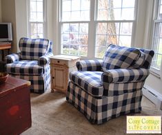 a living room with two chairs and a tv in it's center window sill