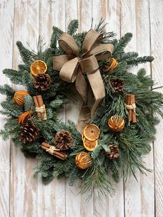 a wreath with oranges, cinnamons and pine cones