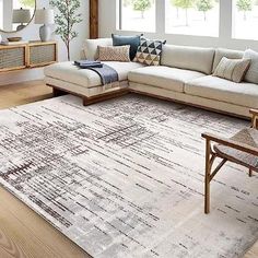 a living room with a large rug on the floor next to a couch and coffee table