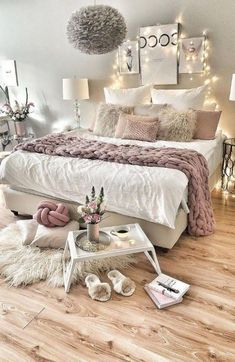 a bedroom with white bedding and lights on the wall above it is decorated in neutral colors