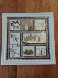 a christmas card is hanging on the wall in front of a wooden floor with a white frame