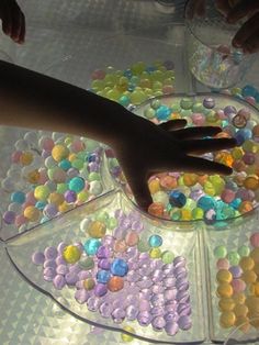 two hands reaching for candy on a tray