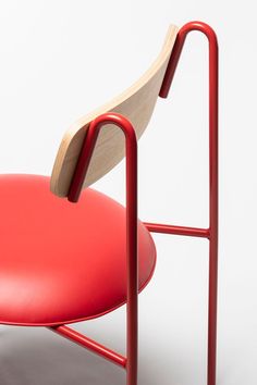 a red chair with a wooden seat and armrests on a white background,