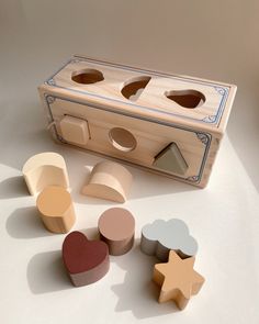 a wooden box with several shapes and sizes on the top, including hearts, stars, and moon shapes