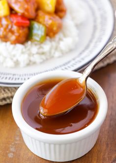 a spoon full of sauce sitting on top of rice