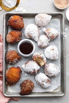 doughnuts and coffee on a tray with powdered sugar in the middle next to them