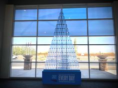 a very tall glass building sitting in front of a large window with the words every day written on it