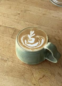 a cappuccino is sitting on a wooden table